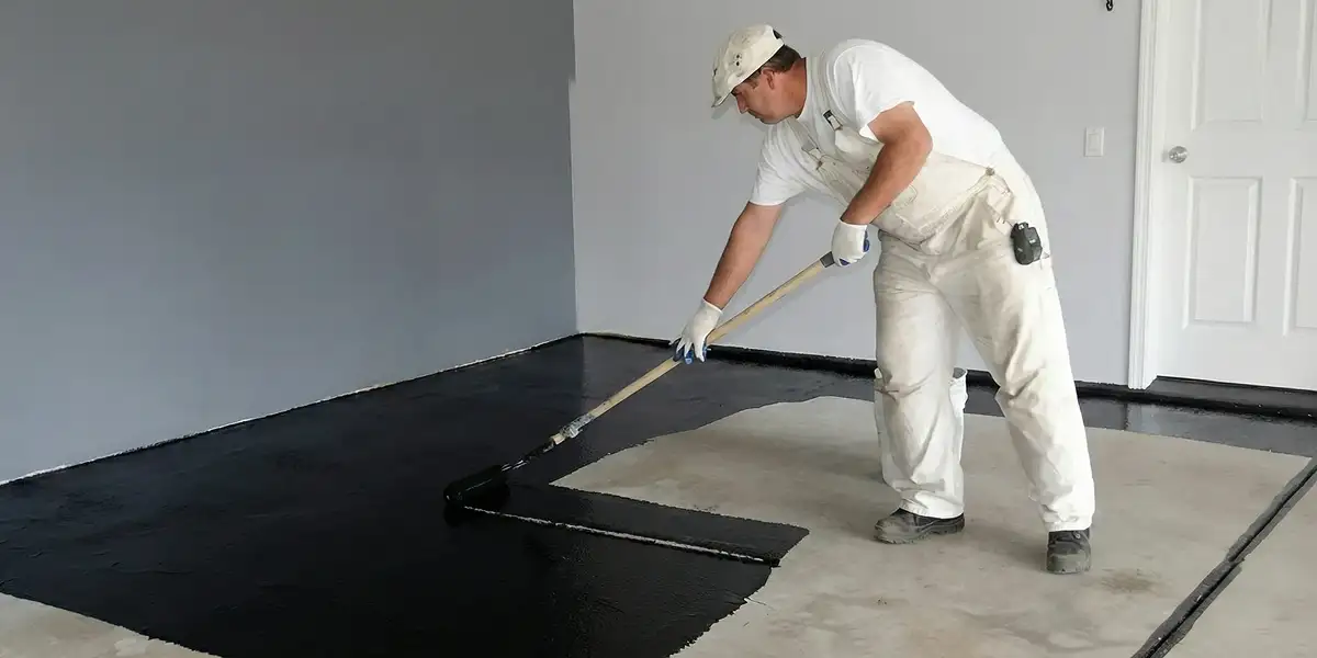 basement waterproofing professional applying waterproof coating to protect a basement floor in Overland Park, KS